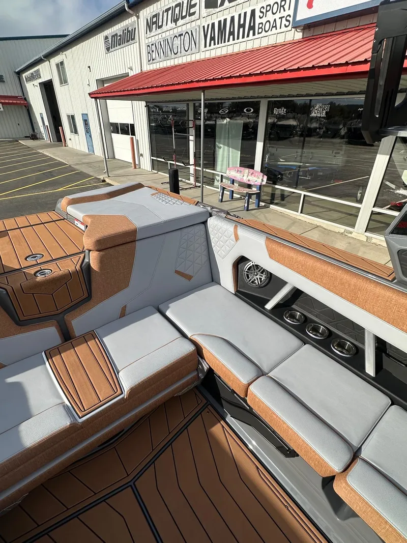 Slide: The Image of 2025 Nautique GS22 boat interior with stylish seating and modern design at a dealership. - 16