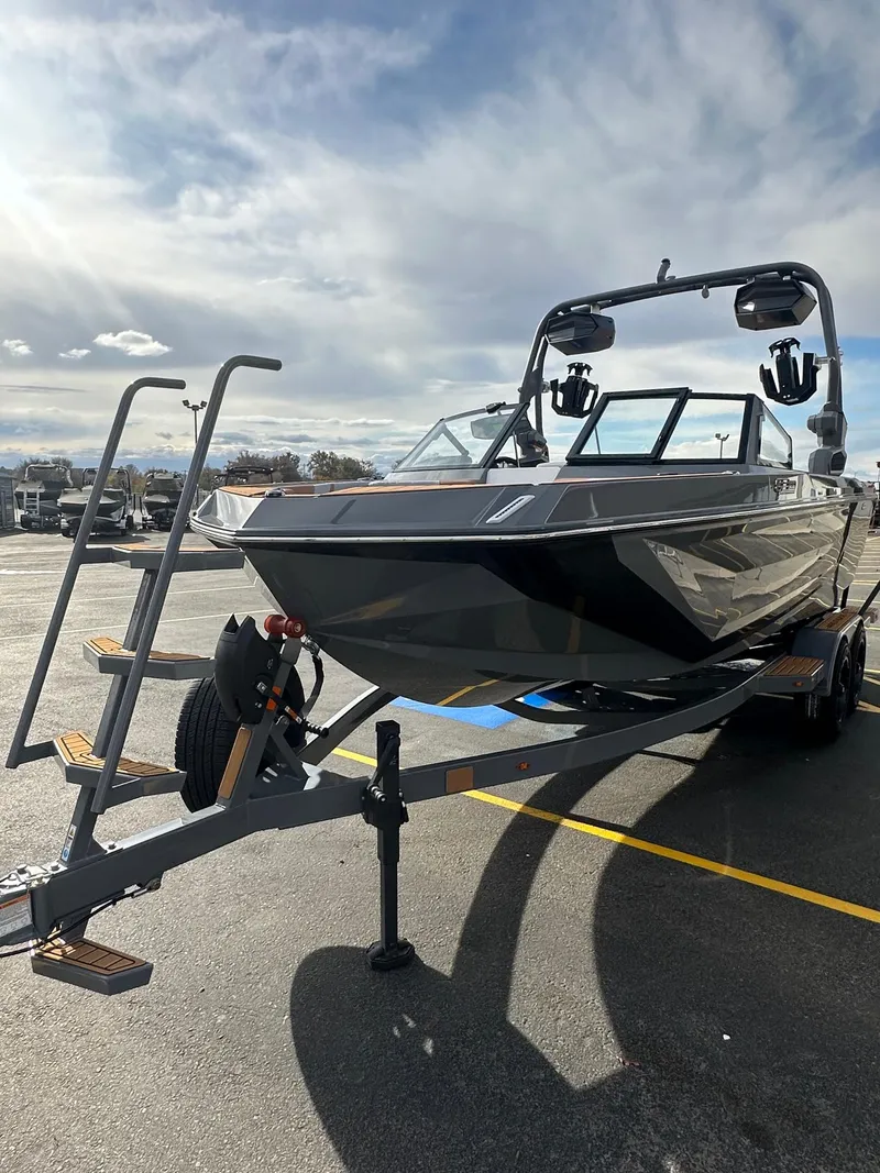 Slide: The Image of 2025 Nautique GS22 boat on trailer under cloudy sky. - 6