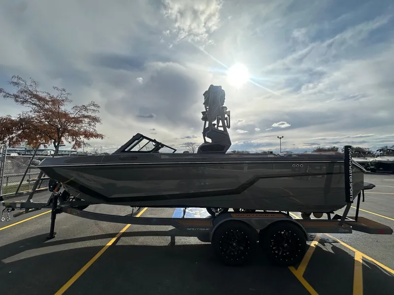 Slide: The Image of 2025 Nautique GS22 boat on trailer under a bright sky. - 7