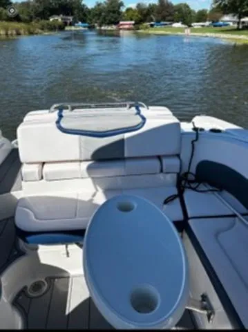 Slide: The Image of 2020 Chaparral 257 SSX boat interior with seating and table on a calm lake. - 12