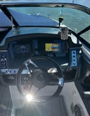 Slide: The Image of 2020 Chaparral 257 SSX boat dashboard with steering wheel and navigation screens. - 22