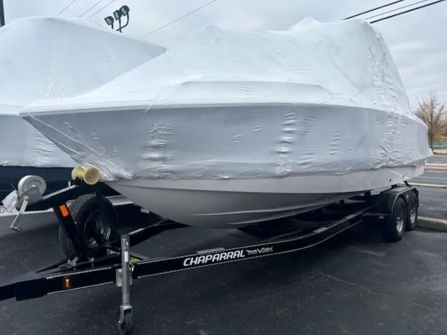 Slide: The Image of 2020 Chaparral 257 SSX boat covered on trailer in parking lot. - 23