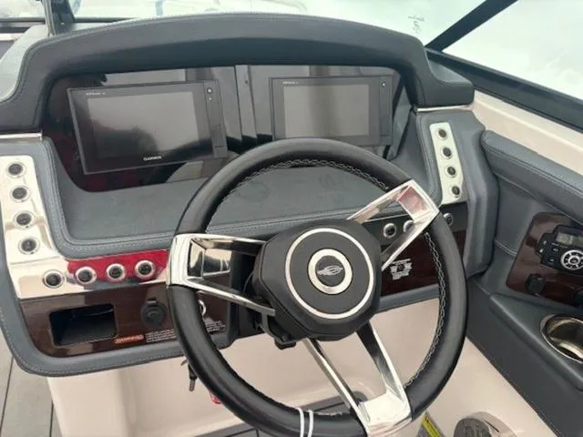 Slide: The Image of 2020 Chaparral 257 SSX boat dashboard with dual screens and steering wheel. - 6
