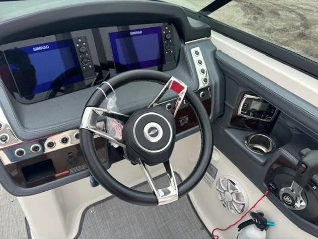 Slide: The Image of 2020 Chaparral 257 SSX boat dashboard with dual Simrad displays and modern steering wheel. - 8