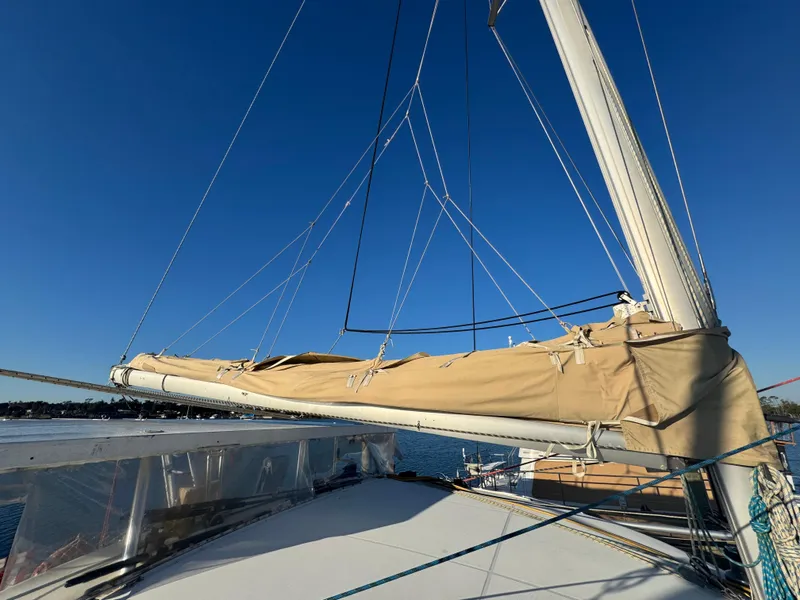 Slide: The Image of Lagoon 410 catamaran sailboat, 2001 model, with sails furled, under clear blue sky. - 16