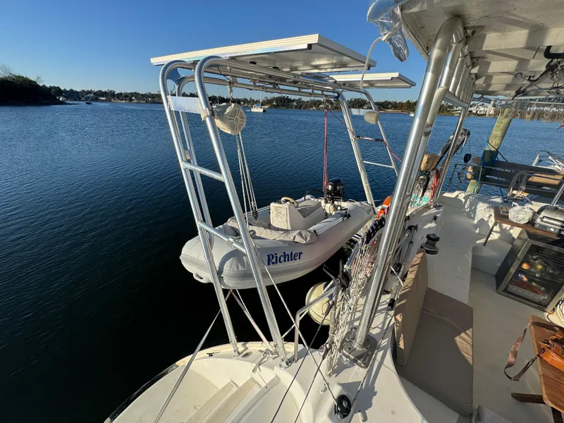 Slide: The Image of Lagoon 410 catamaran (2001) with dinghy on davits, moored on calm water. - 19