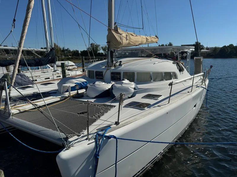Slide: The Image of 2001 Lagoon 410 catamaran docked at marina under clear blue sky. - 2