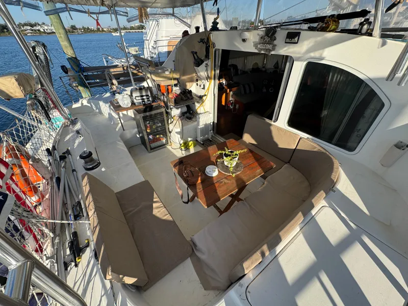 Slide: The Image of Lagoon 410 catamaran interior, 2001 model, featuring cozy seating and a wooden table. - 21