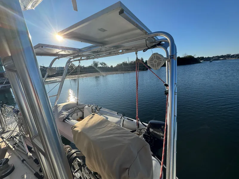 Slide: The Image of Lagoon 410 catamaran, 2001 model, with solar panels on a sunny day by the water. - 24