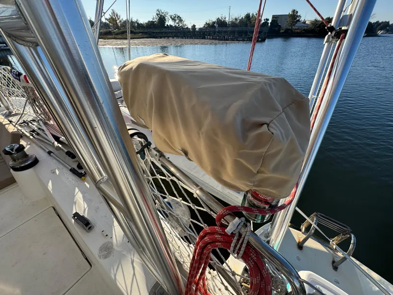 Slide: The Image of Lagoon 410 sailboat deck with covered equipment, docked by a serene waterfront. - 25