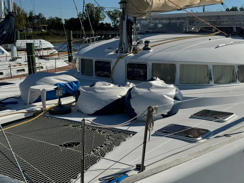 Slide: The Image of 2001 Lagoon 410 catamaran docked, featuring spacious deck and netting. - 3