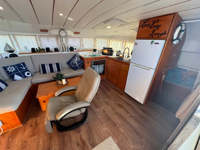 Slide: The Image of Interior of 2001 Lagoon 410 catamaran with cozy seating and kitchen area. - 32