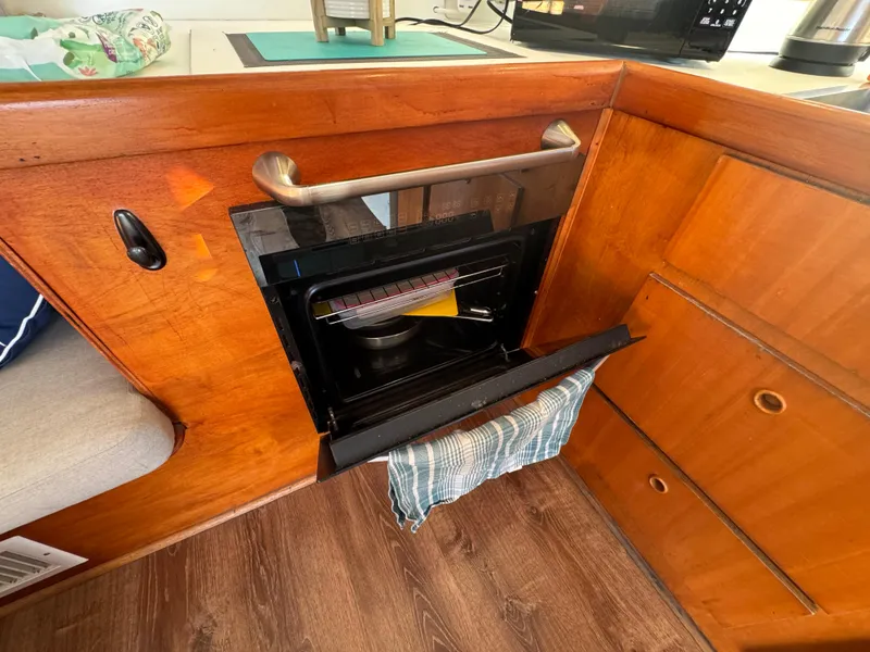 Slide: The Image of Interior of 2001 Lagoon 410 yacht with open oven and wooden cabinetry. - 33