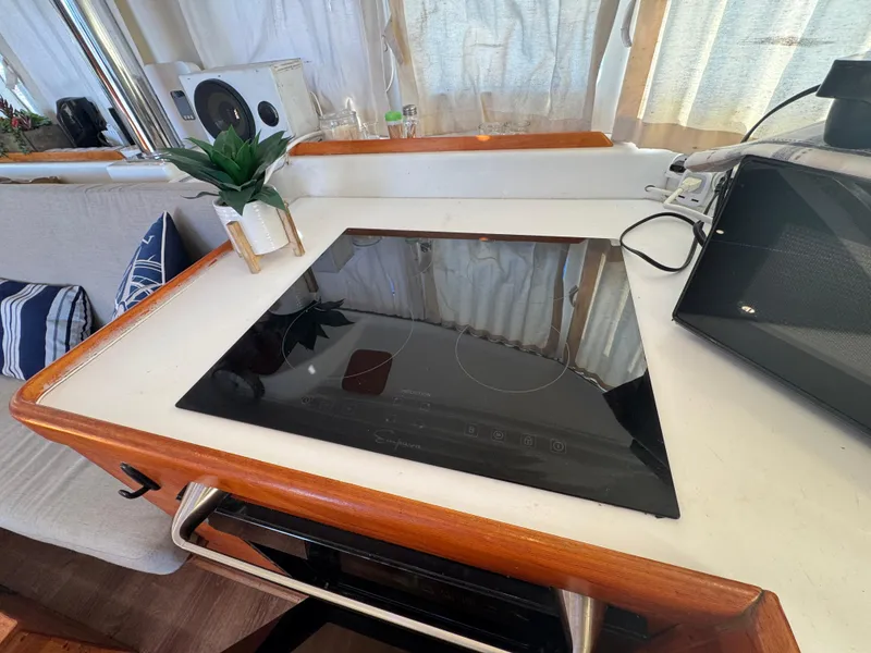 Slide: The Image of Modern kitchen area on 2001 Lagoon 410 catamaran with sleek cooktop. - 34