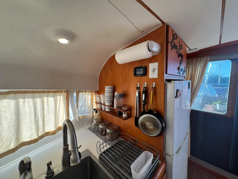 Slide: The Image of Lagoon 410 catamaran kitchen interior, featuring sink, utensils, and storage, 2001 model. - 35