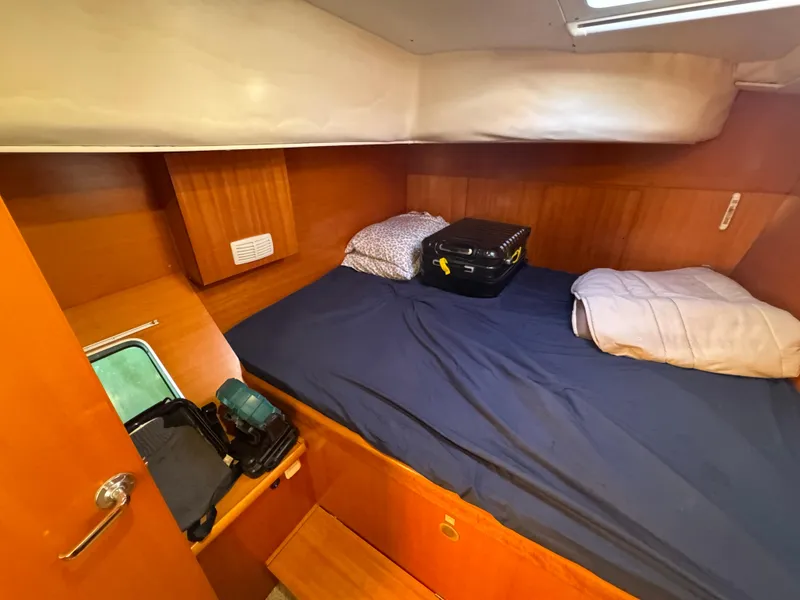 Slide: The Image of Cozy cabin interior of 2001 Lagoon 410 catamaran with bed and luggage. - 44