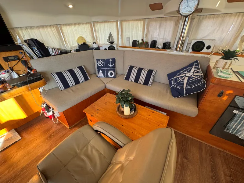 Slide: The Image of Cozy interior of 2001 Lagoon 410 catamaran with nautical-themed cushions and wooden furnishings. - 49