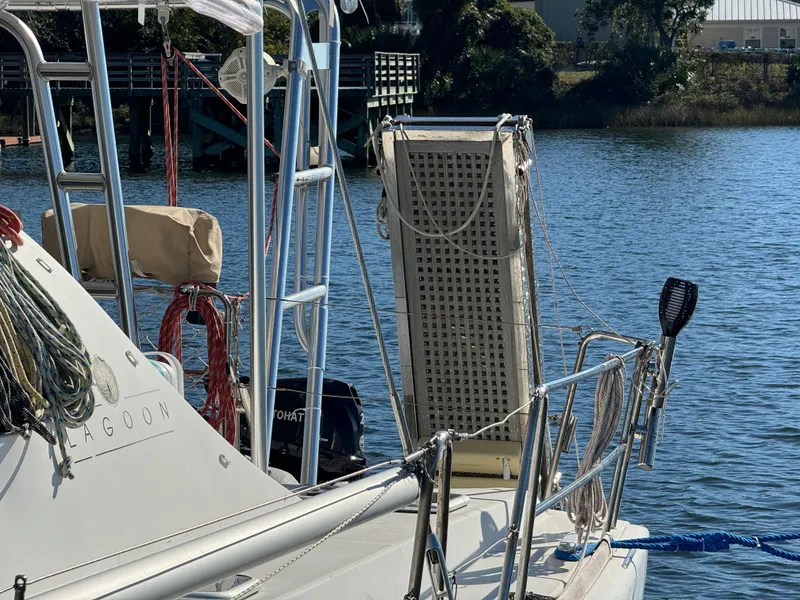 Slide: The Image of Lagoon 410 catamaran from 2001 docked by a serene waterfront. - 8