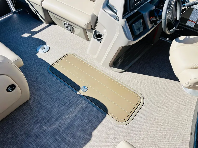 Slide: The Image of 2025 Sun Tracker Party Barge 22 RF XP3 interior with beige seating and storage compartment. - 22