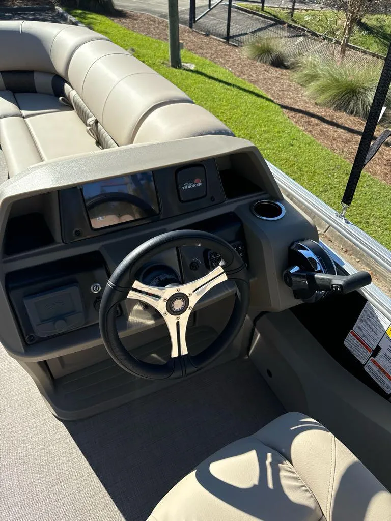 Slide: The Image of 2025 Sun Tracker SportFish 22 DLX boat interior with steering wheel and seating. - 7