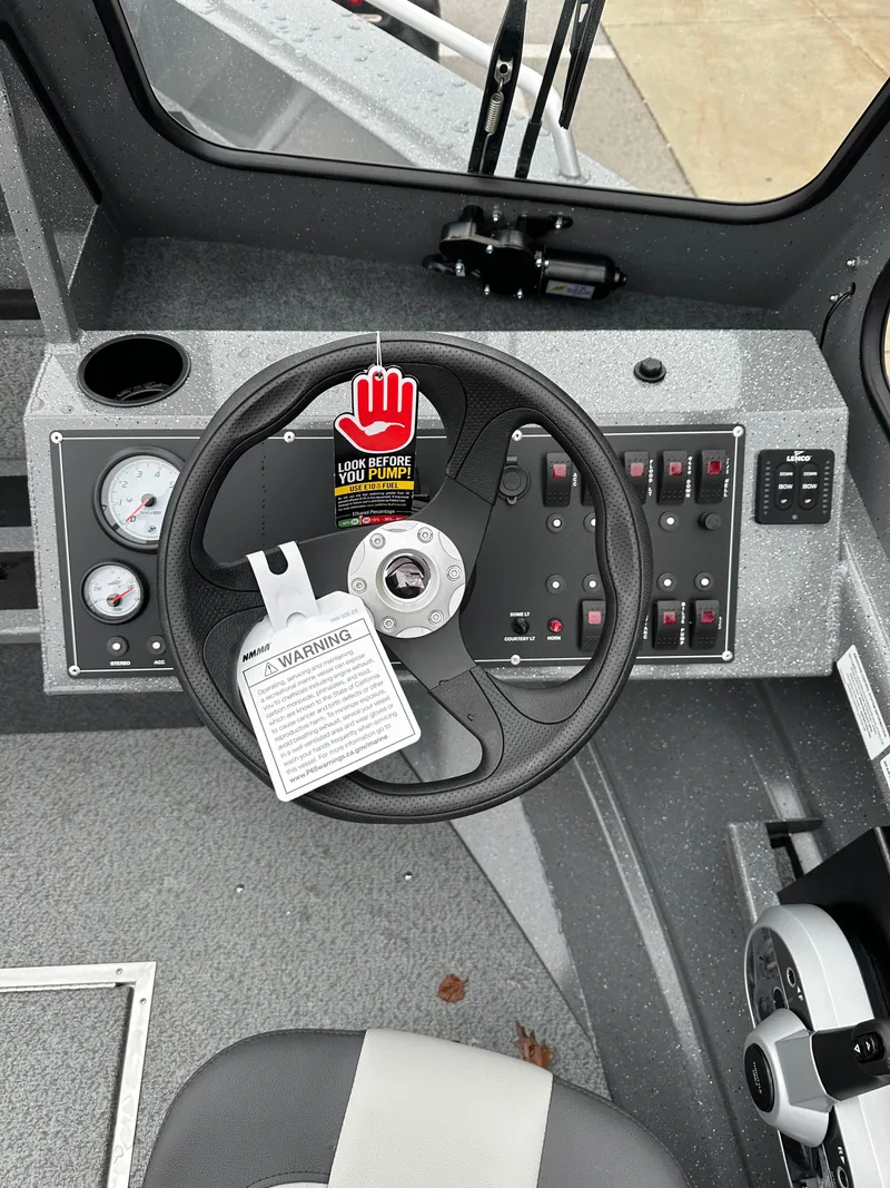 Slide: The Image of 2025 Spartan 200 Astoria boat dashboard with steering wheel and control panel. - 11