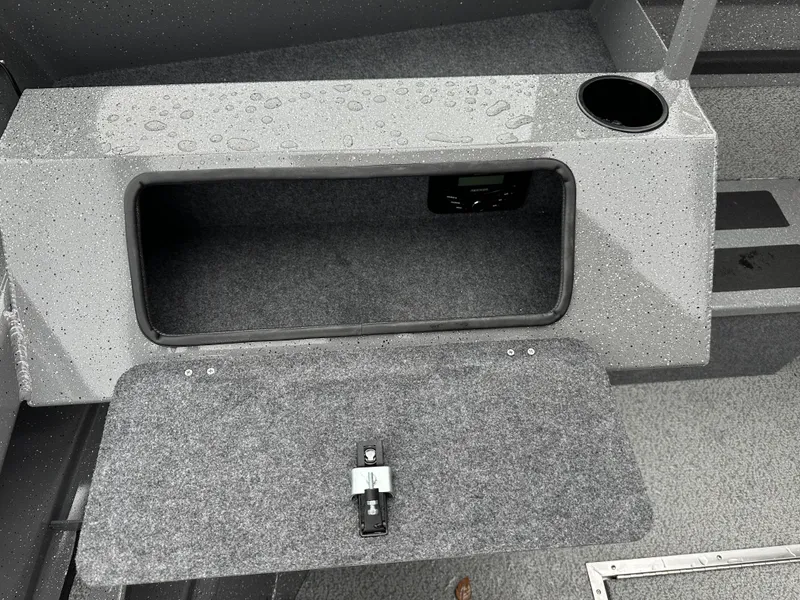 Slide: The Image of 2025 Spartan 200 Astoria storage compartment with cup holder and carpeted interior. - 15