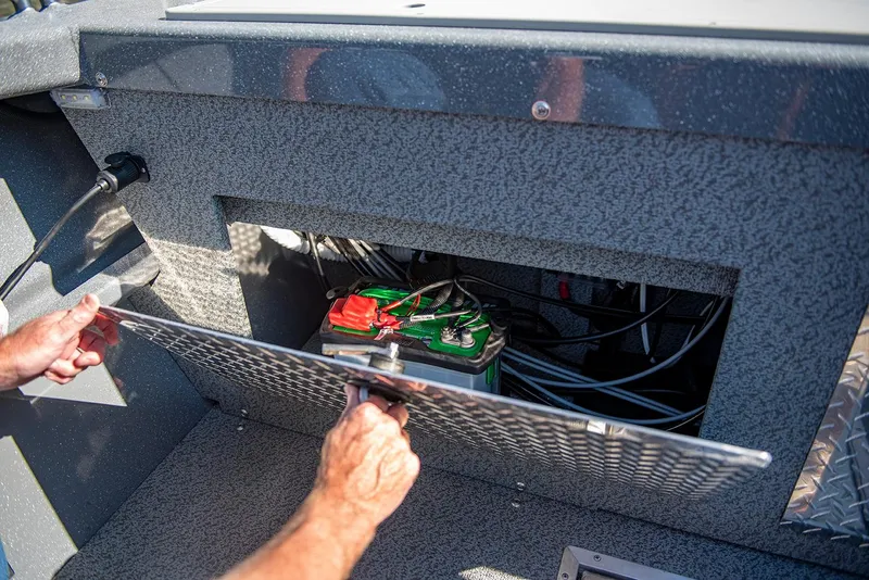 Slide: The Image of Man accessing battery compartment in 2025 Spartan 200 Astoria boat. - 22