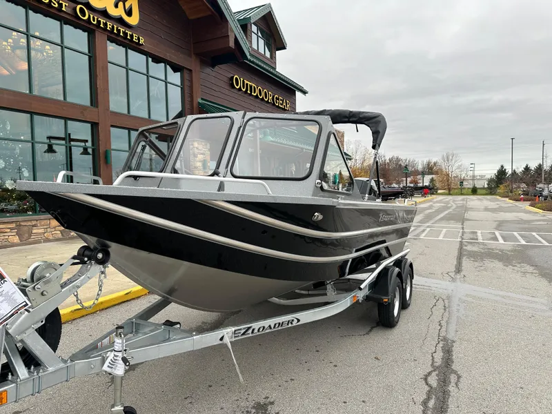 Slide: The Image of 2025 Spartan 200 Astoria boat on trailer outside outdoor gear store. - 4