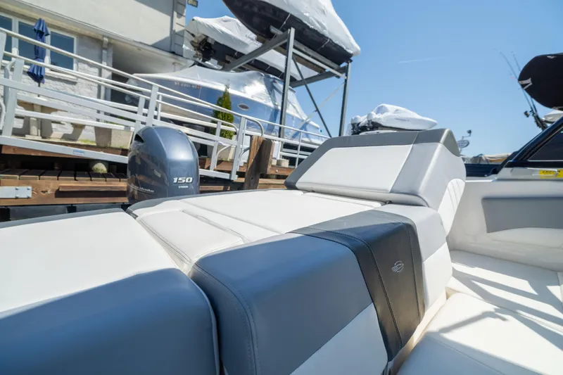 Slide: The Image of 2022 Chaparral 21 SSi OB boat with Yamaha 150 engine, docked under clear blue sky. - 12