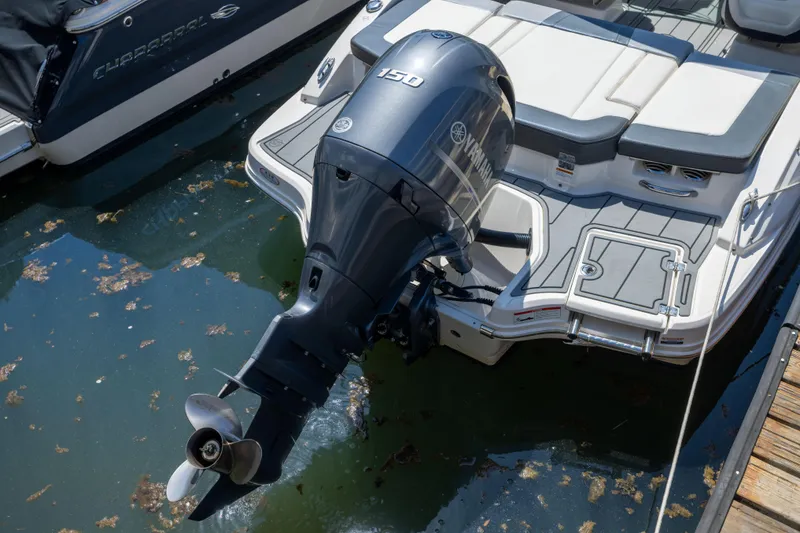 Slide: The Image of 2022 Chaparral 21 SSi OB boat with Yamaha outboard motor docked in water. - 21