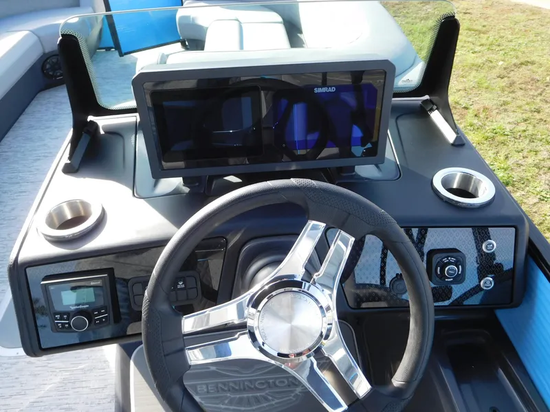 Slide: The Image of 2025 Bennington 24 MFB boat dashboard with steering wheel and navigation display. - 2