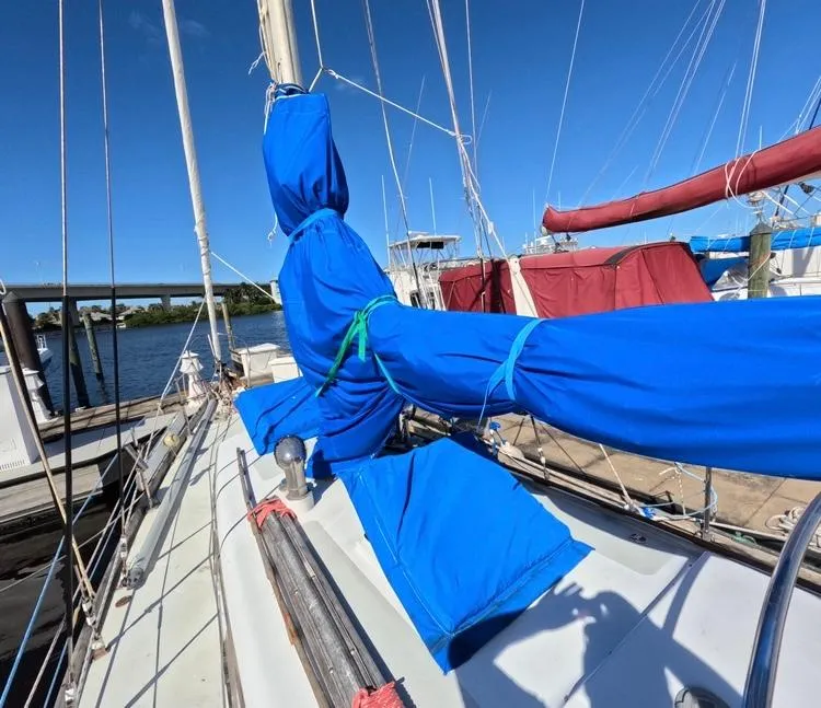 Slide: The Image of 1972 Cheoy Lee Luders 36 sailboat with blue sail covers at a marina. - 13