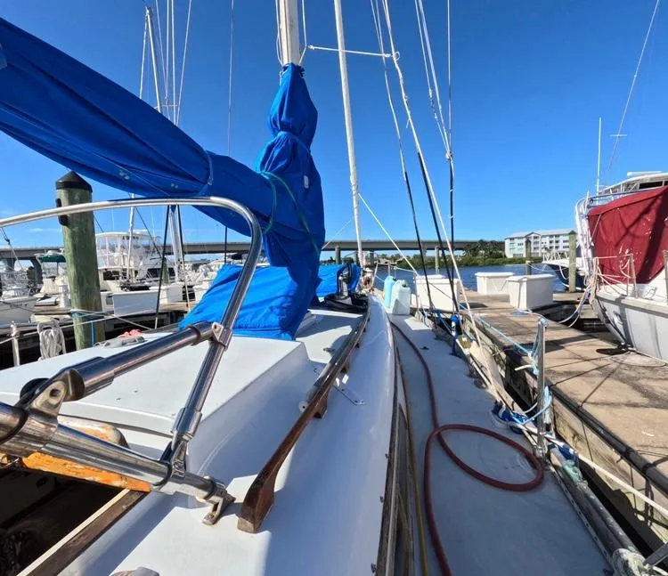 Slide: The Image of 1972 Cheoy Lee Luders 36 sailboat docked, featuring blue sail cover and clear sky. - 17