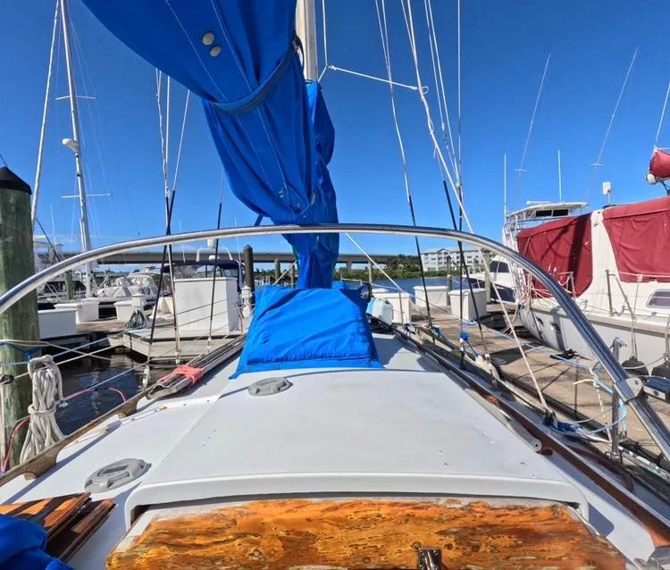 Slide: The Image of 1972 Cheoy Lee Luders 36 sailboat docked, featuring blue sail cover and wooden deck details. - 18