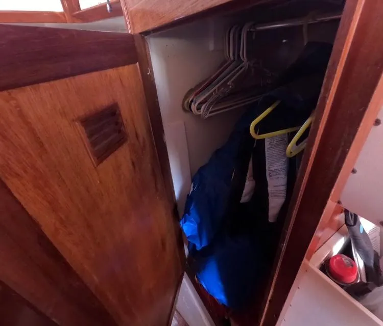 Slide: The Image of Wooden closet interior on 1972 Cheoy Lee Luders 36 sailboat with hangers and clothing. - 35