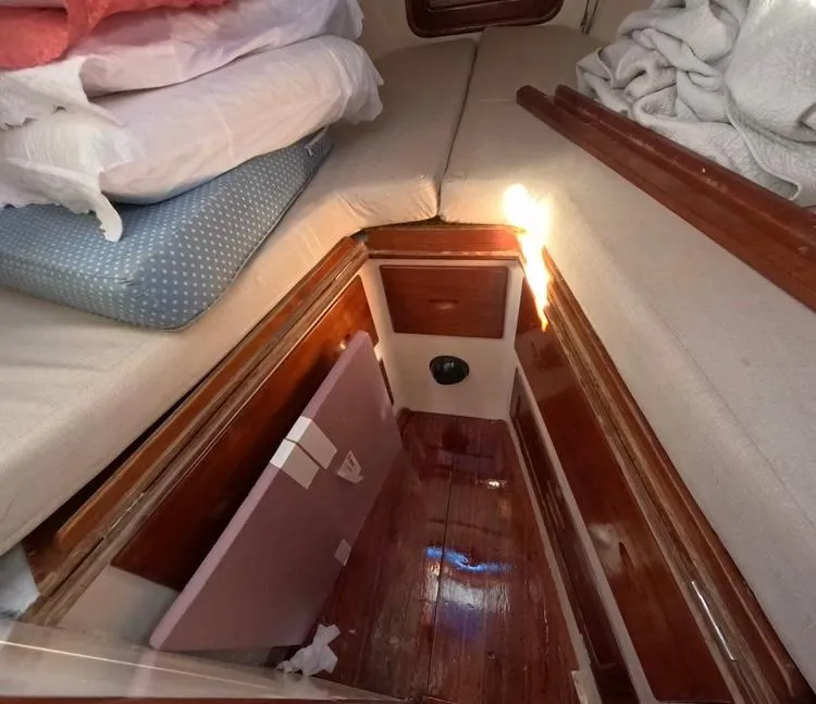 Slide: The Image of Interior cabin of 1972 Cheoy Lee Luders 36 sailboat with wooden flooring and cushions. - 36