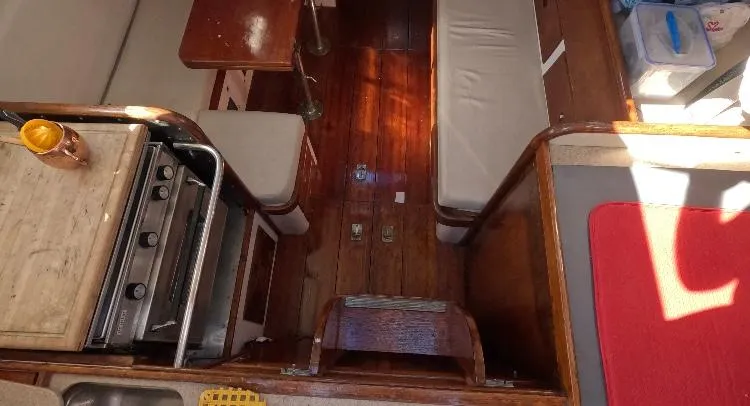 Slide: The Image of Interior of 1972 Cheoy Lee Luders 36 sailboat with wooden flooring and compact kitchen area. - 42
