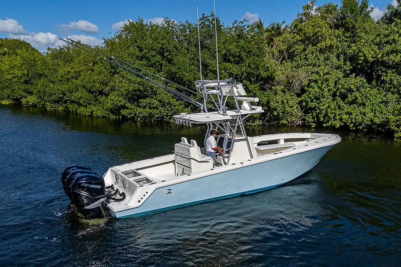 Slide: The Image of 2018 SeaVee 370z boat cruising on a calm river with lush greenery. - 11