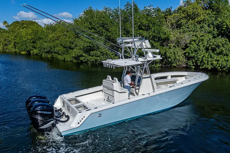 Slide: The Image of 2018 SeaVee 370z boat cruising on a river with lush greenery. - 12
