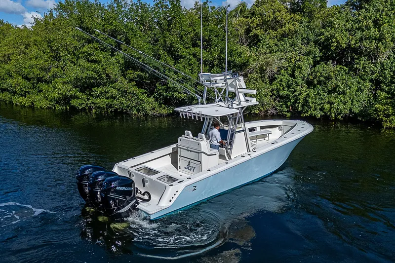 Slide: The Image of 2018 SeaVee 370z boat cruising on a scenic waterway with lush greenery. - 18