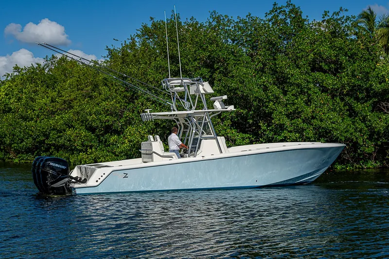 Slide: The Image of 2018 SeaVee 370z boat on calm water near lush greenery. - 2