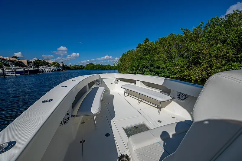 Slide: The Image of 2018 SeaVee 370z boat interior with seating, surrounded by lush greenery and calm waters. - 21
