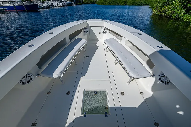 Slide: The Image of 2018 SeaVee 370z boat with spacious deck and seating, docked on calm water. - 23