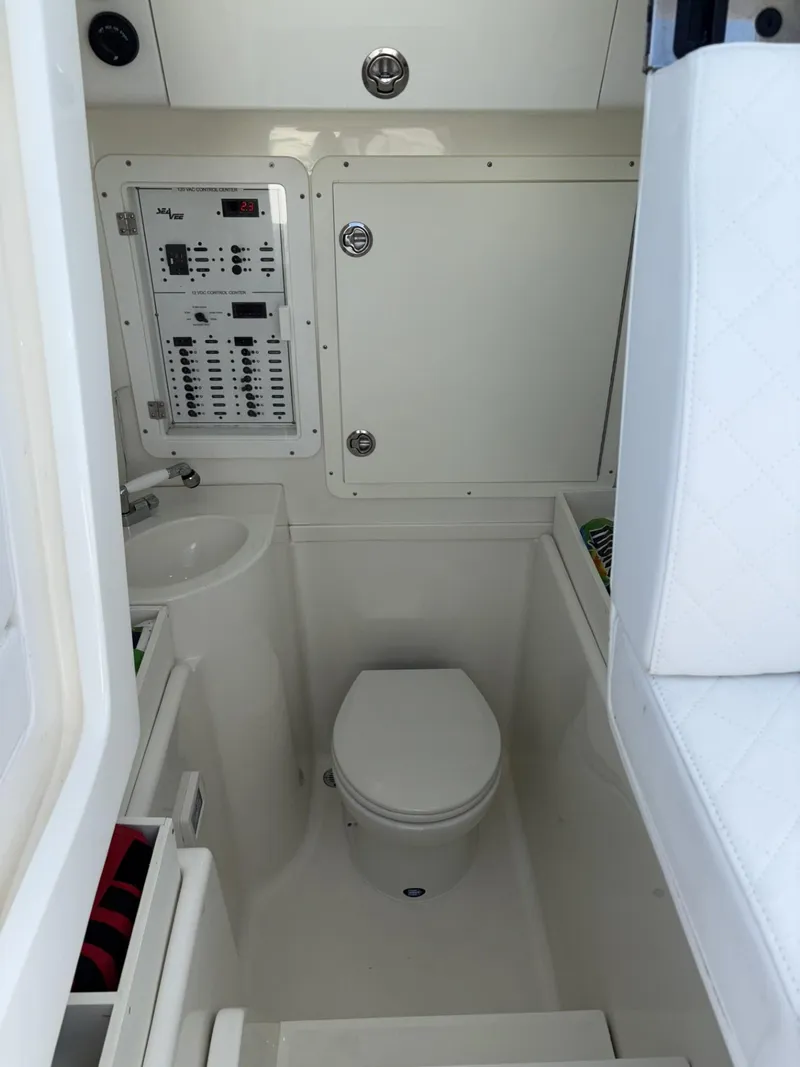 Slide: The Image of 2018 SeaVee 340Z boat interior with compact bathroom and control panel. - 27