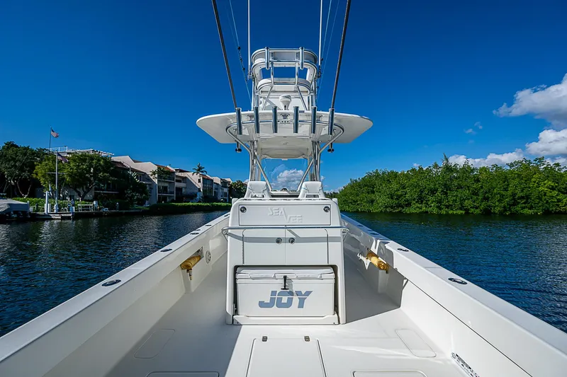 Slide: The Image of 2018 SeaVee 370z boat on water, clear sky, lush greenery. - 37