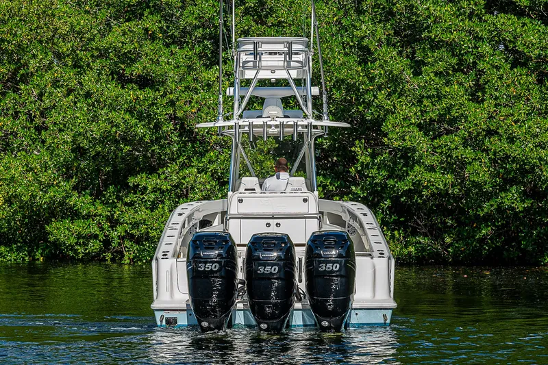 Slide: The Image of 2018 SeaVee 340Z boat with triple 350 horsepower engines on a calm waterway. - 4