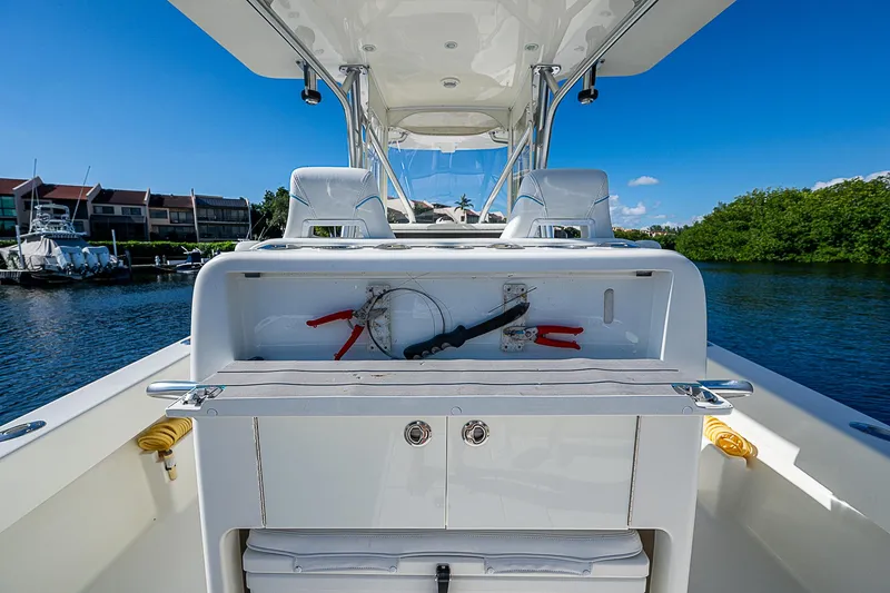 Slide: The Image of 2018 SeaVee 370z boat interior with helm station and seating, docked by waterfront homes. - 42