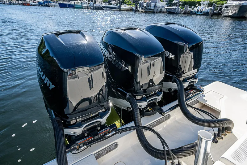 Slide: The Image of Triple Mercury outboard engines on 2018 SeaVee 370z boat, docked by the water. - 44