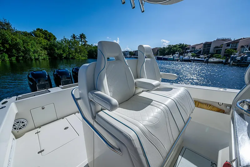 Slide: The Image of 2018 SeaVee 370z boat with luxurious seating, docked by a scenic waterfront. - 50