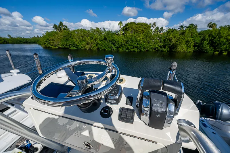 Slide: The Image of 2018 SeaVee 370z boat helm with steering wheel and controls, scenic waterway view. - 54